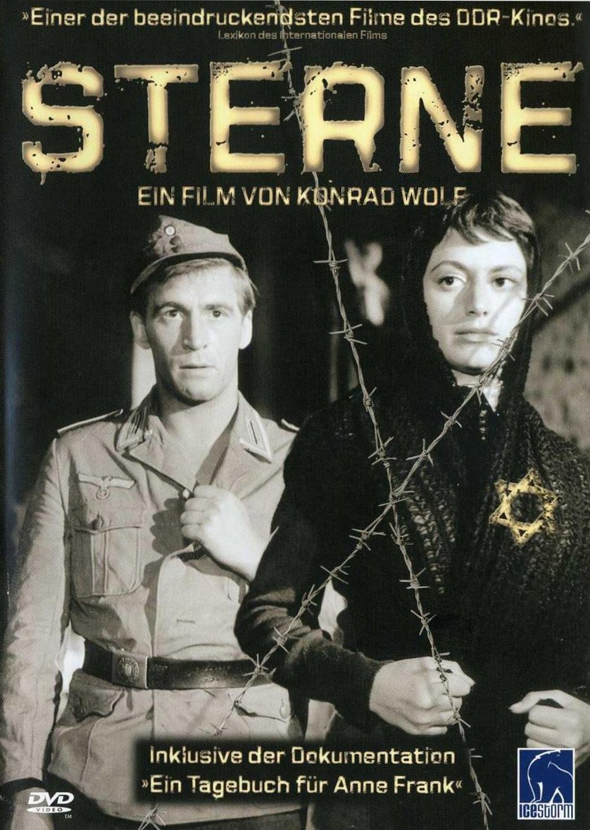 A imagem é a capa de um DVD do filme alemão "Sterne" (Estrelas), dirigido por Konrad Wolf.  A capa é em preto e branco, mostrando um homem em uniforme militar alemão ao lado de uma mulher que usa uma estrela de Davi, símbolo do povo judeu. Entre eles, há um arame farpado, representando uma barreira física e um símbolo de conflito e aprisionamento. O fundo é escuro, dando ênfase aos personagens. O título do filme está em letras grandes e estilizadas. Na parte inferior, há informações adicionais sobre uma documentação incluída no DVD, possivelmente relacionada ao Diário de Anne Frank. A capa sugere um filme sobre a Segunda Guerra Mundial e o Holocausto, provavelmente abordando os horrores do nazismo e seu impacto na vida das pessoas. A imagem é dramática e evoca sentimentos de sofrimento e opressão.